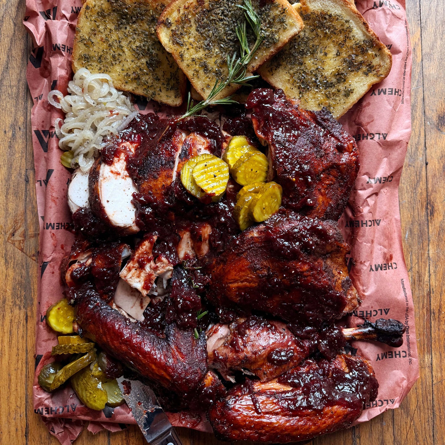 a platter of smoked spatchcock turkey with cranberry sauce and stuffing toast